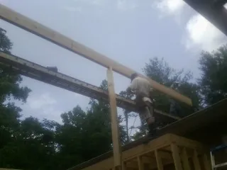 Carpenter setting a ridge beam over a new addition frame — Ice Dam Removal by Roofing Brothers in Pelican Rapids