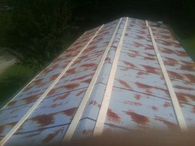Rusted metal roof panels with new wood purlins before replacement — Storm Damage Roof Repair in Pelican Rapids by Roofing Brothers