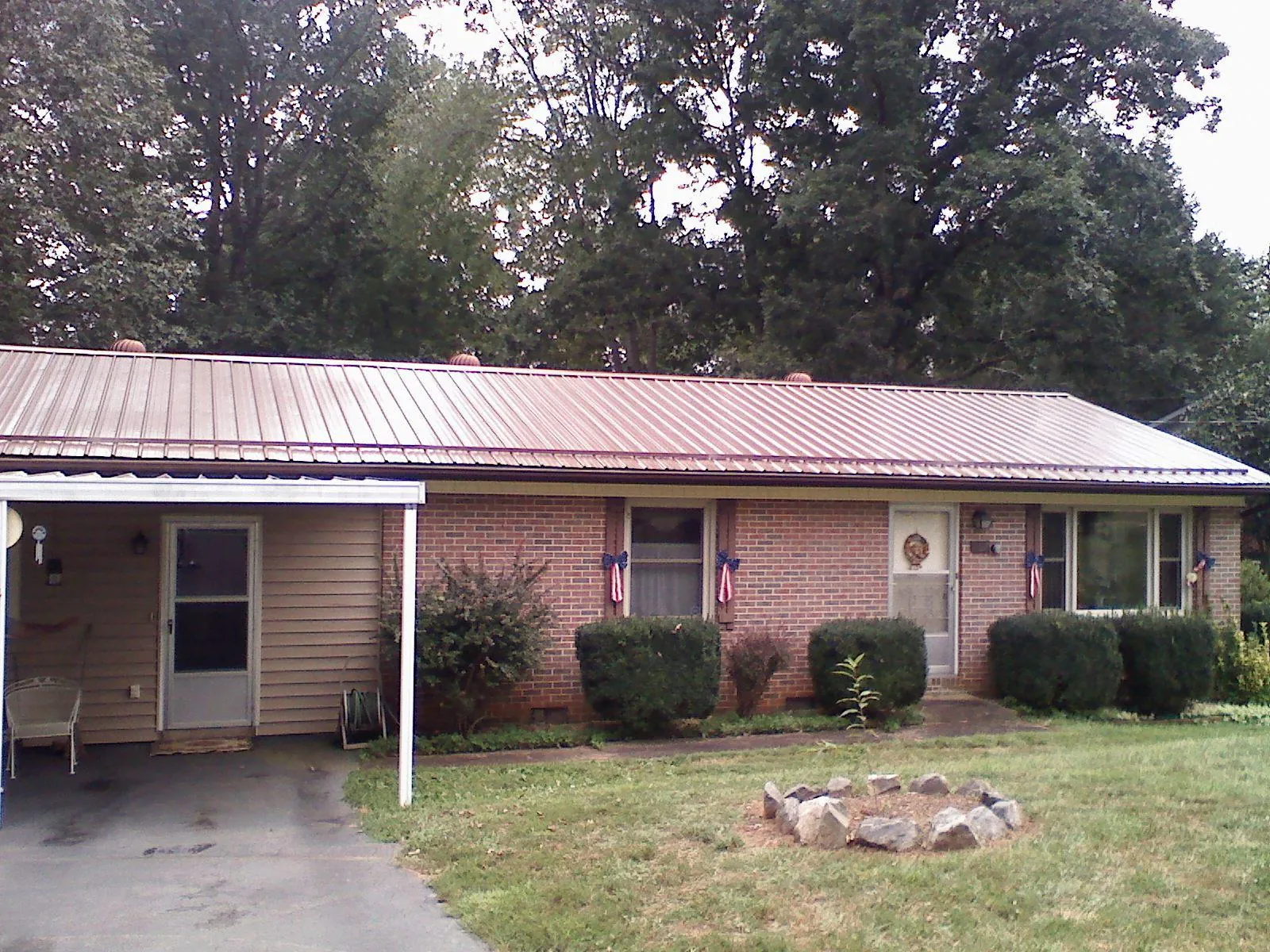 Bronze metal roof and carport on a brick ranch home — Roof Repair work by our crew in Pelican Rapids
